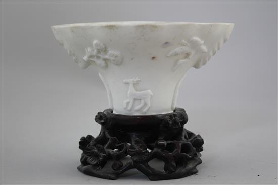 A Chinese Dehua blanc-de-chine libation cup, late 17th / early 18th century, 13cm, carved wood stand